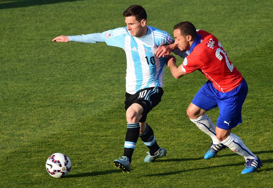Lionel Messi tenta di sfuggire dal controllo di Marcelo Diaz (Afp)